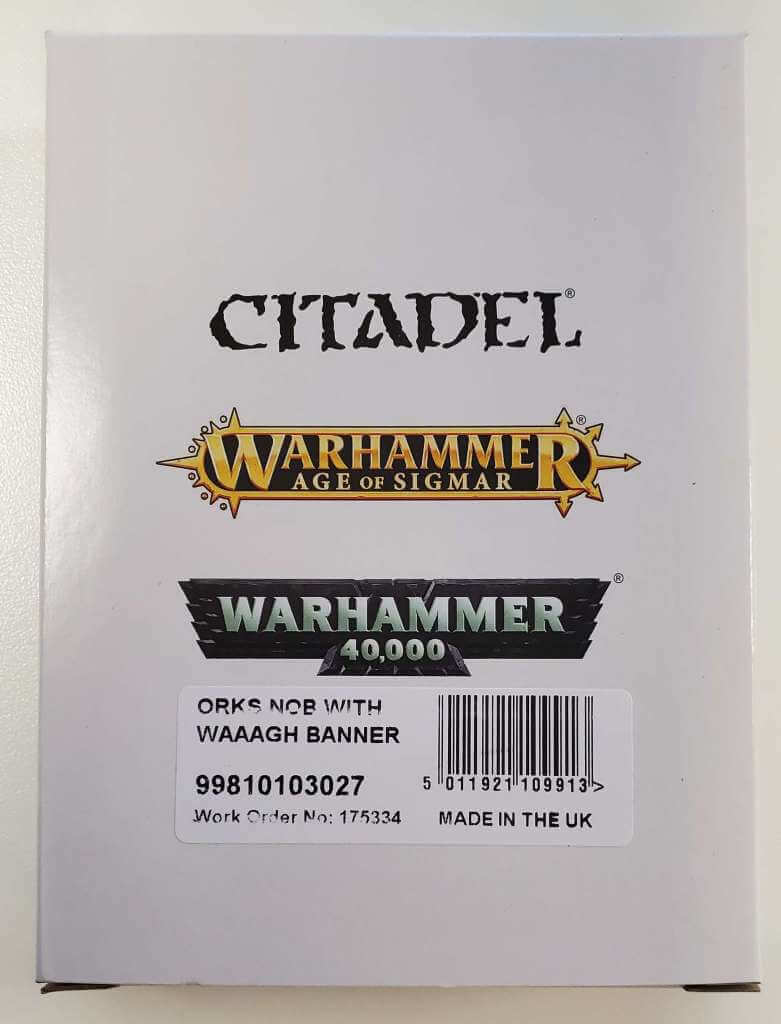 Packaging for 'Ork Nob with Waaagh! Banner' model kit from Citadel's Warhammer 40,000 series. The box is predominantly white with the model name and number '99810103027' visible.