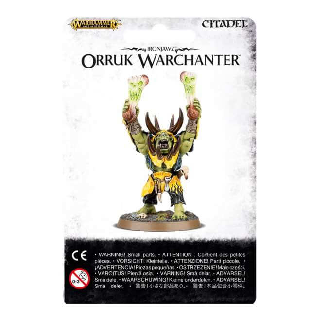 Packaging for Orruk Warclans Warchanter miniature, featuring the assembled and painted model on the front with protective warning labels on the sides.