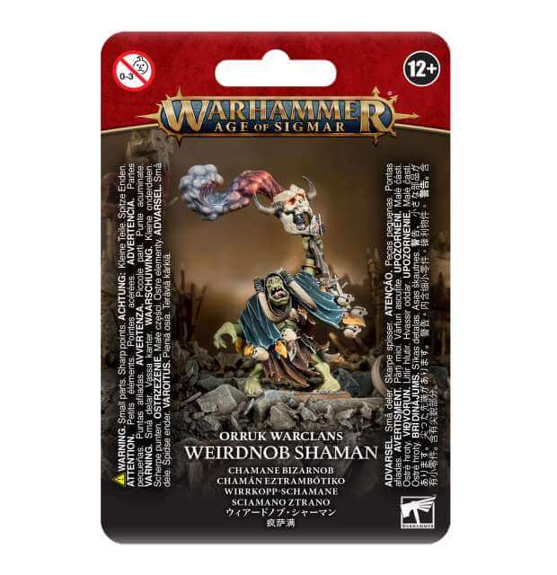 Packaging for Orruk Warclans Weirdnob Shaman miniature, featuring the assembled and painted model in a dynamic pose with a staff, on a red and black card with game-related text.