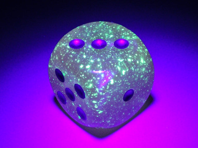 An example of the Chessex Borealis Luminary Pink with gold 30mm d6 under a black light