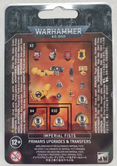 Packaging for 'Imperial Fists Primaris Upgrades & Transfers' kit, displaying various small plastic model pieces including shoulder pads, heads, and arms, arranged neatly on a card with a Warhammer 40,000 backdrop.