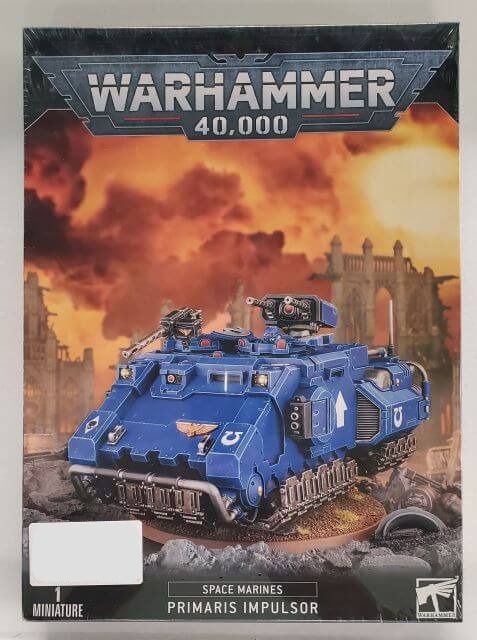 A product image featuring the packaging for a Warhammer 40,000 Space Marines Primaris Impulsor model kit. The box displays the model with a blue and black color scheme against a dramatic sky backdrop.