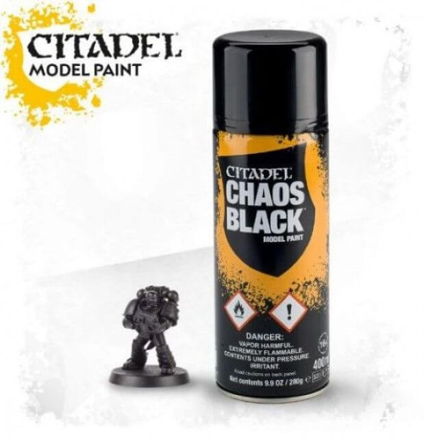 A can of Citadel model paint labeled 'Chaos Black' alongside a miniature figurine.