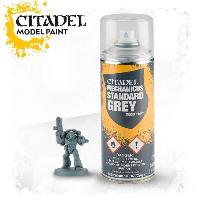A spray paint can labeled 'Citadel Model Paint - Mechanicus Standard Grey' with a small model figure painted grey next to it.