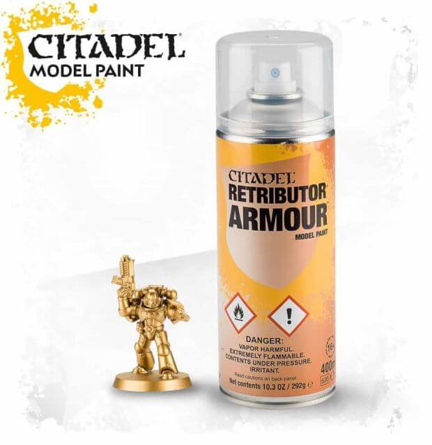 A can of Citadel model paint labeled 'Retributor Armor' spray paint alongside a miniature figurine.